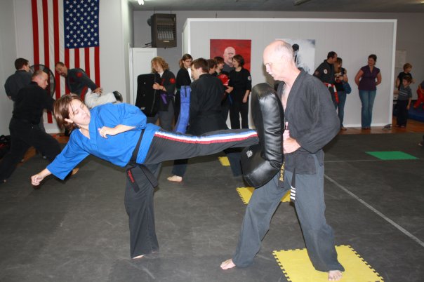Tony hold the pad while Gina Slams a side kick